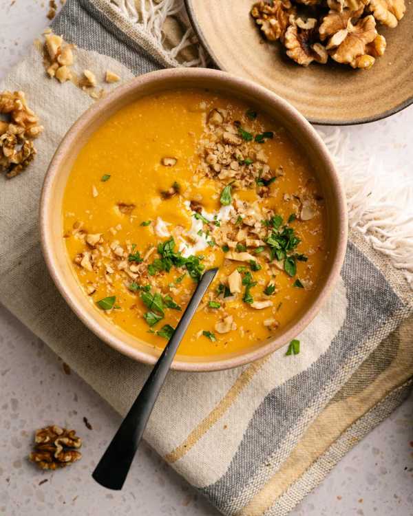 Cremige orange Kürbissuppe mit Kokosmilch und gerösteten Walnüssen